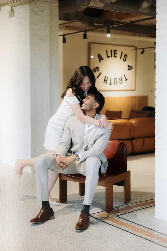 Grace embracing Neel as he sits in a lounge chair