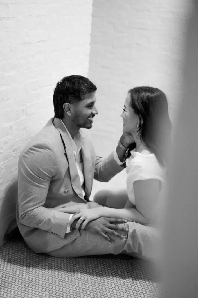 Neel and Grace smiling at one another, seated together
