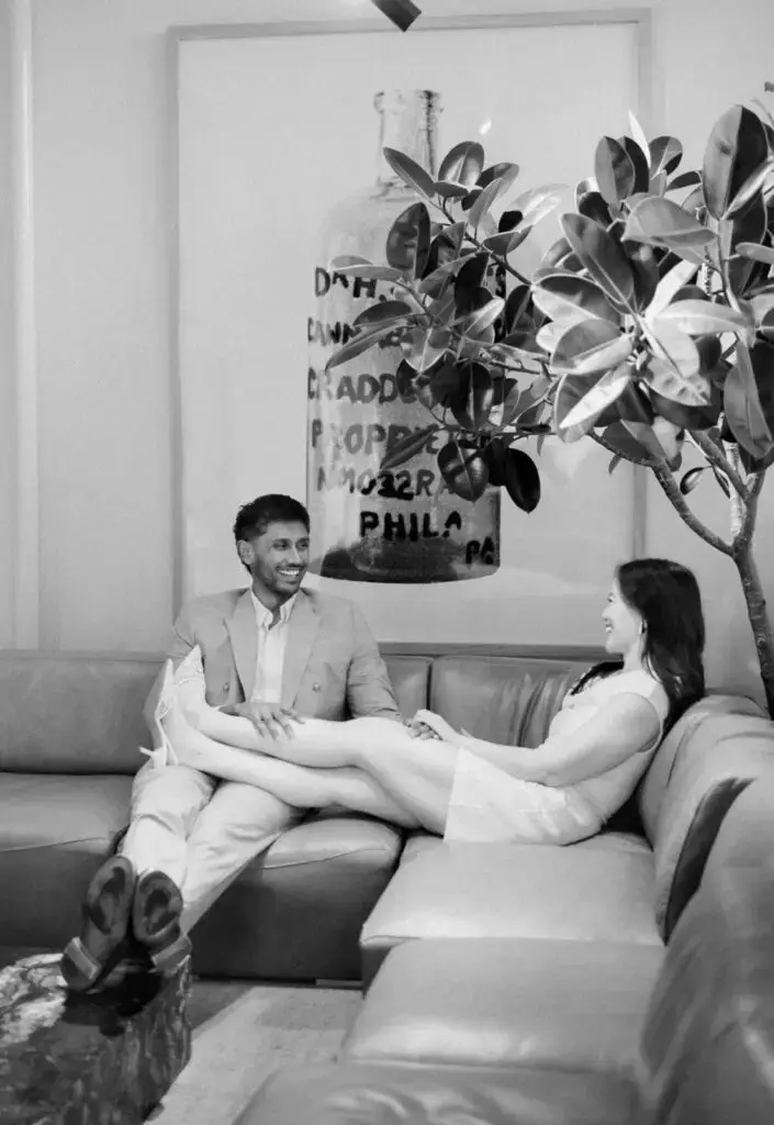 Neel and Grace laughing together on a sofa